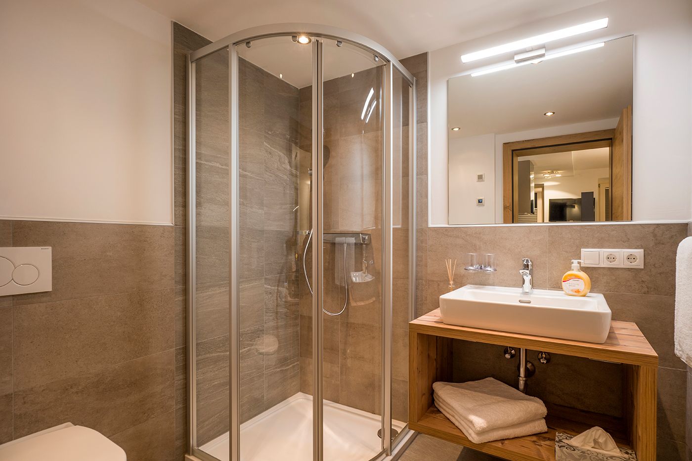 A photo of a shower and a sink in front of a mirror