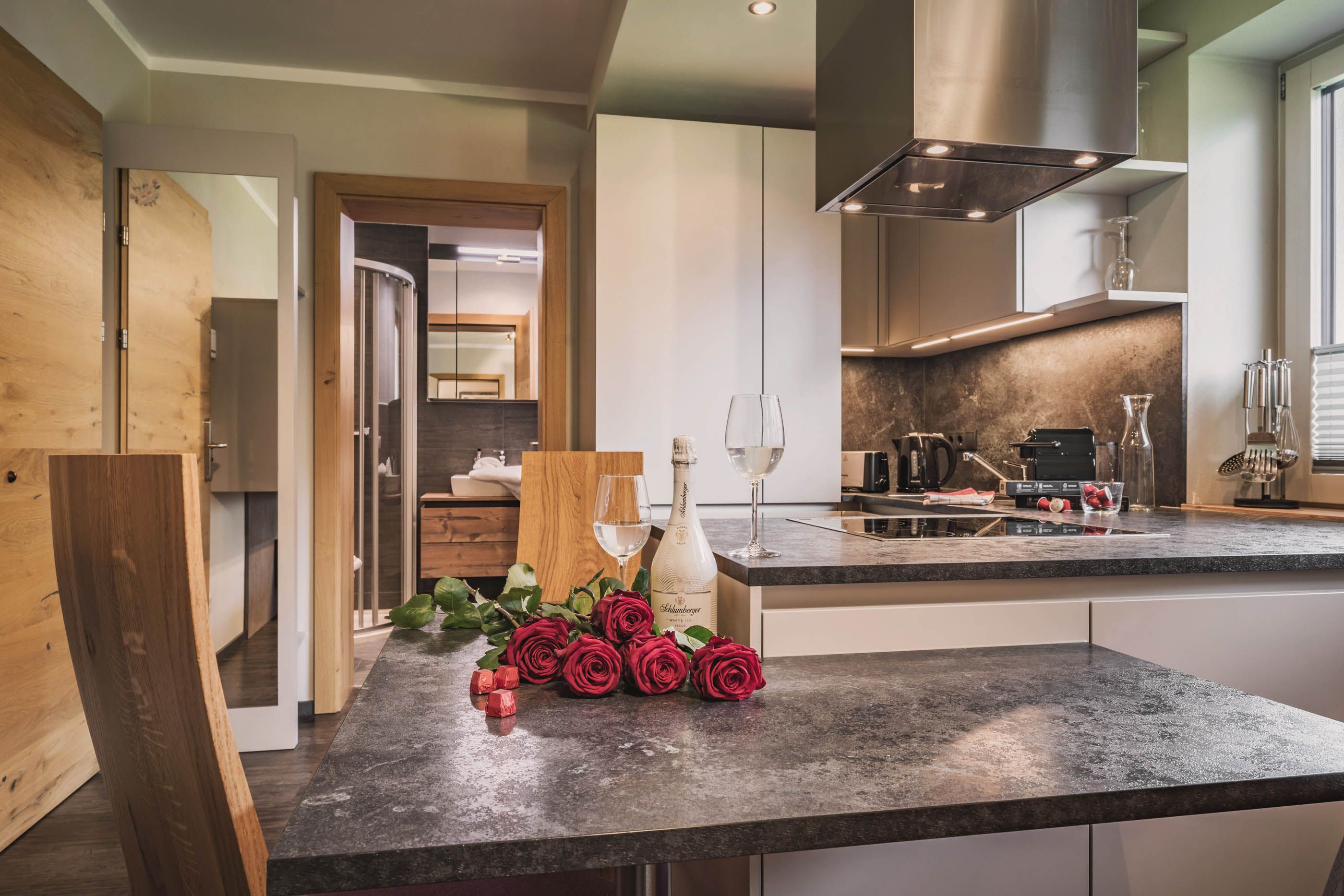 Fully equipped kitchen with kitchen island, red roses and sparkling wine glasses
