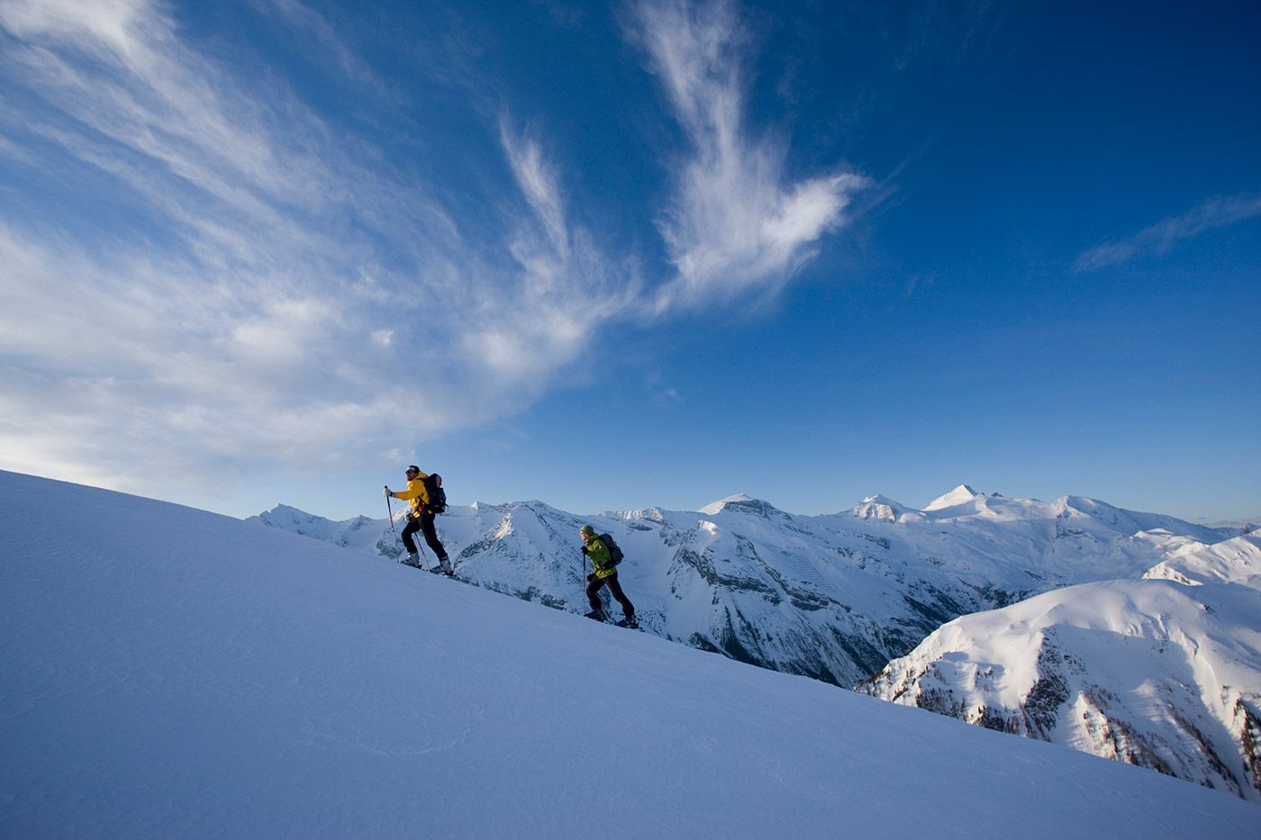 Ski tourer climbing to Grüblspitze with skis on backpack