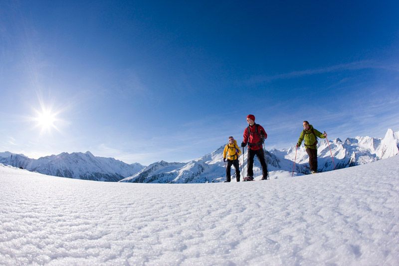 Snowshoe hiker in deeply snow-covered mountain landscape