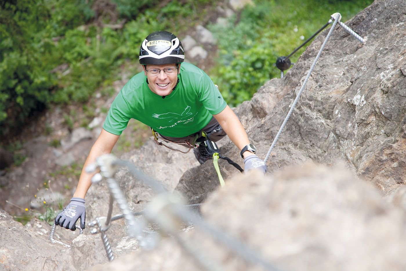 Climber on rock with safety equipment and climbing gear
