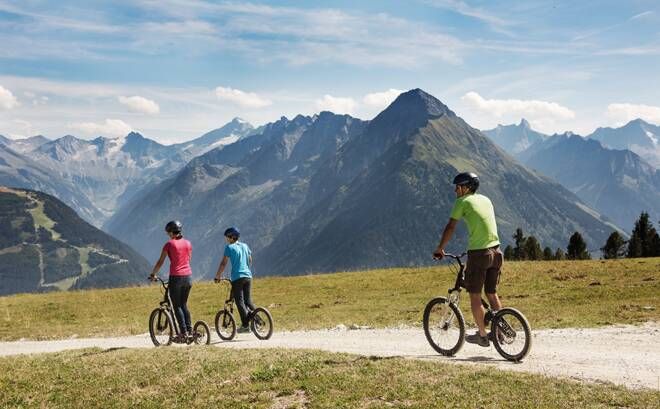 Family with scooters on mountain path at Penken Mayrhofen